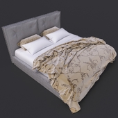 кровать серая с одеялом и подушками