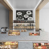 A modern coffee shop with stone and wood elements and a refrigerator with dessert and sweets