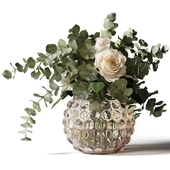Bouquet of roses and eucalyptus in a glass pimpled vase