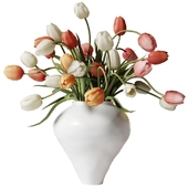 Multi-colored tulips in a white clay vase