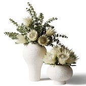 Белые протеи и эвкалипт в современных белых глиняных вазах